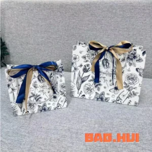ถุงกระดาษใส่ของขวัญลายดอกไม้ ผูกริบบิ้นสองชั้น สีขาวลายกรม